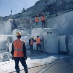 Construction workers with helmets and vests at a marble quarry site in Turkey.